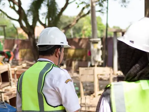 Construction worker in safety vest and hard hat on a job site